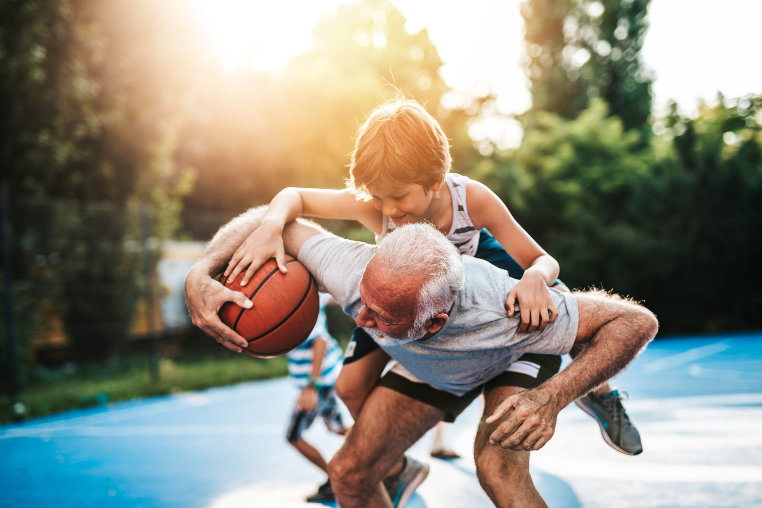 Grandfather and his grandson playing basketball.